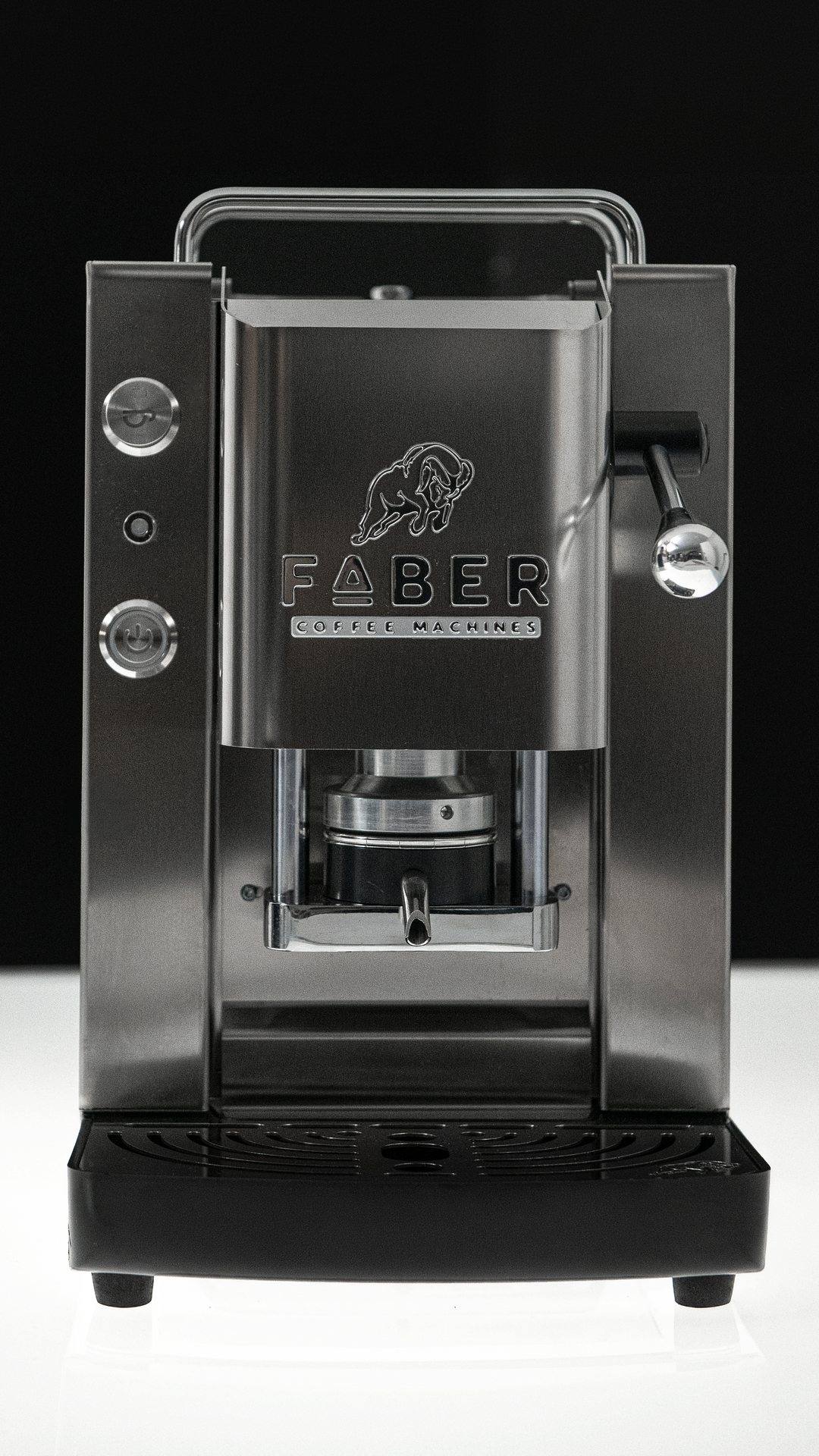 Una macchina Faber nera e acciaio, vista frontale, su sfondo scuro.